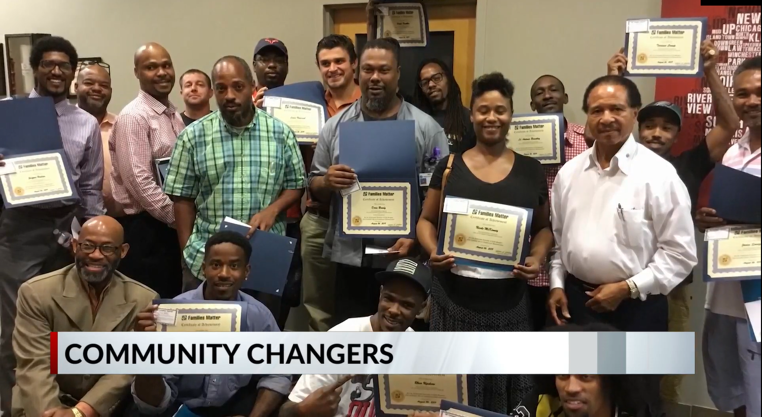 Group of men holding certificates of completion of the fatherhood class